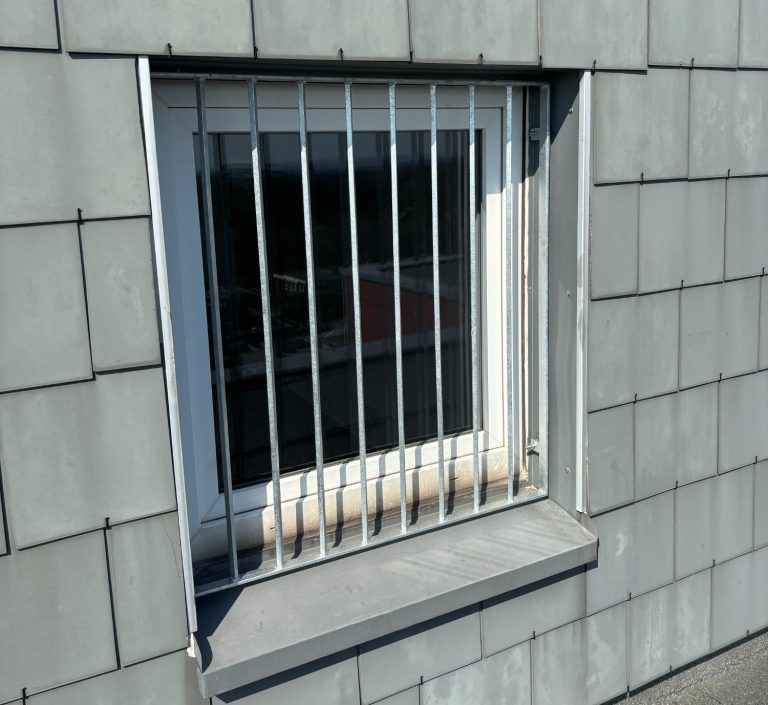 Sicherungsgitter aus verzinktem Stahl vor einem Dachfenster, Mehrfamilienhaus in Herten